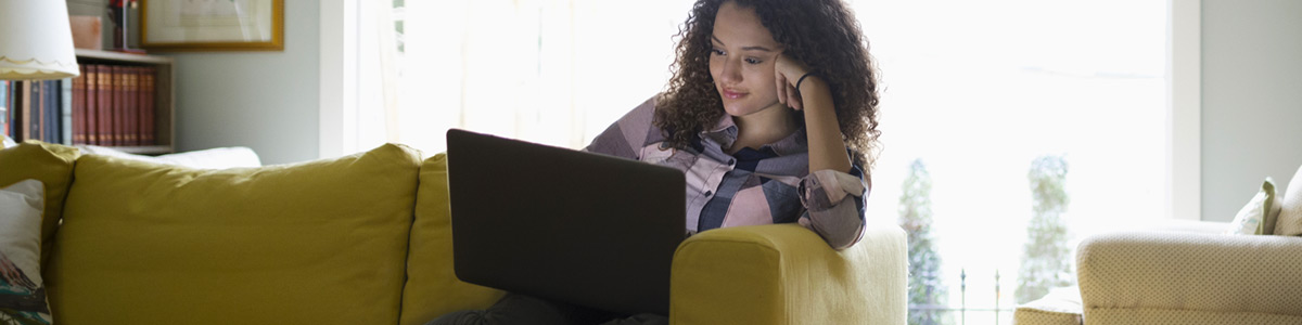 woman using a laptop sitting on the couch