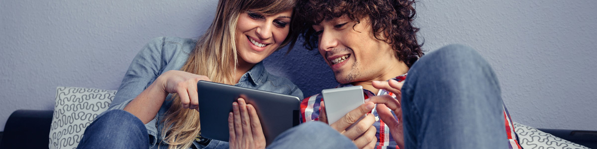 couple looking at phone and tablet